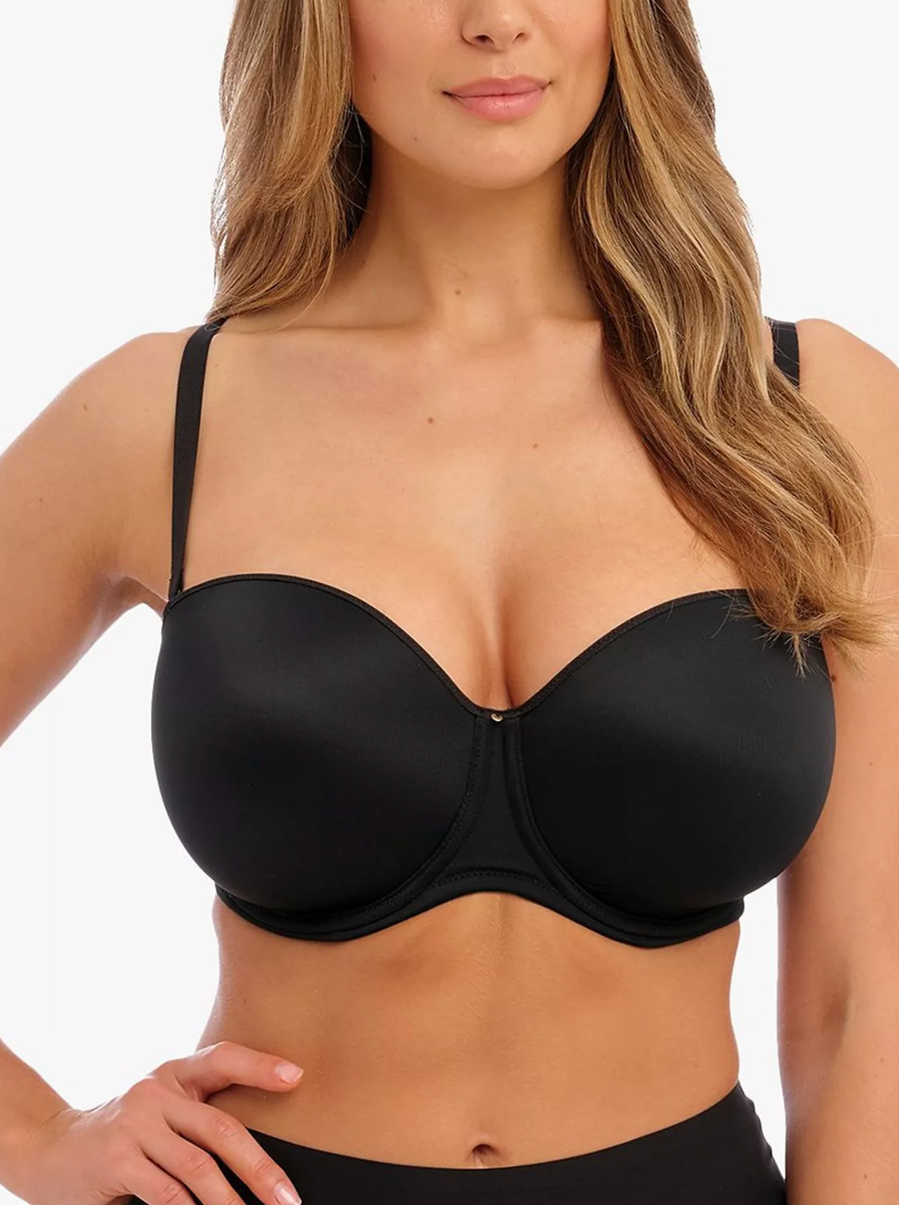 Woman wearing a black bra against a white background