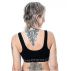 Person wearing a black post surgery bra with heart patterns on a white background