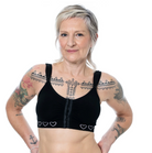 Woman wearing a black post surgery bra with heart patterns on a white background