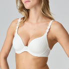 White bra worn by a model on a plain background
