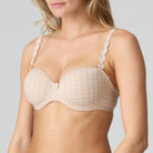 Beige bra with floral lace details on a plain background