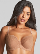 Woman wearing a beige bra against a gray background