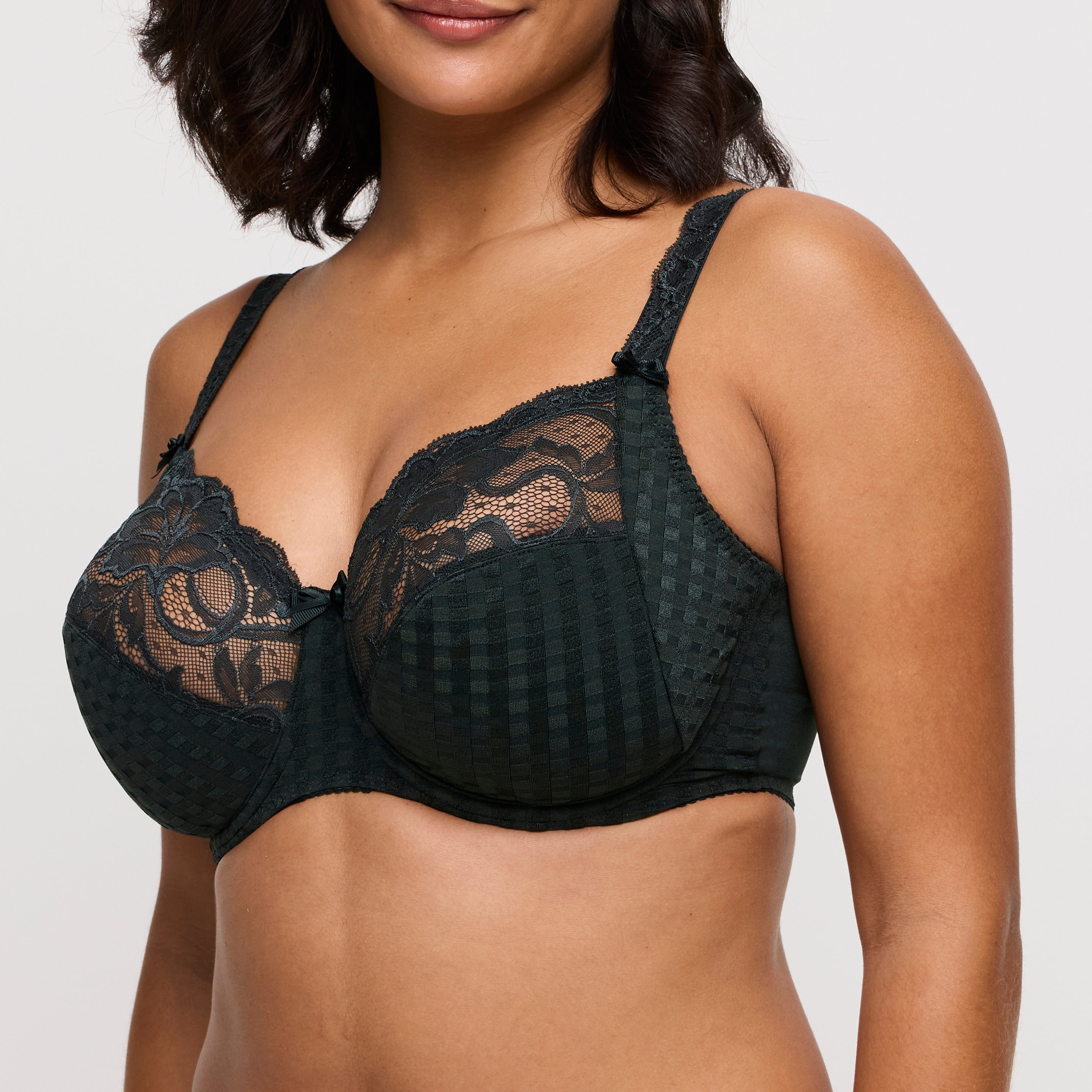 green lace bra worn by a model on a plain background