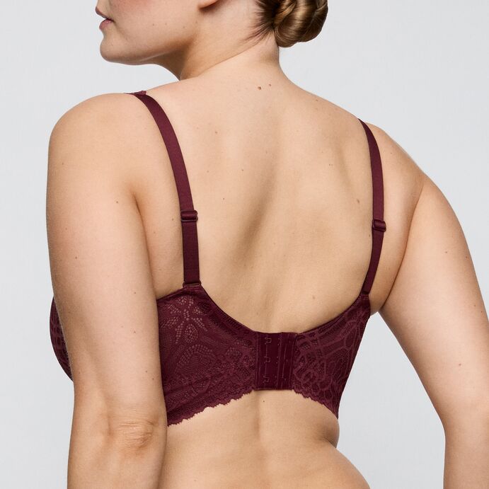 Burgundy lace bra worn by a model on a light gray background