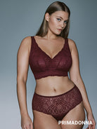 A woman modeling a matching burgundy lace bralette and high-waisted brief set against a solid gray studio background. The brand name PRIMADONNA is printed in white text at the bottom right.