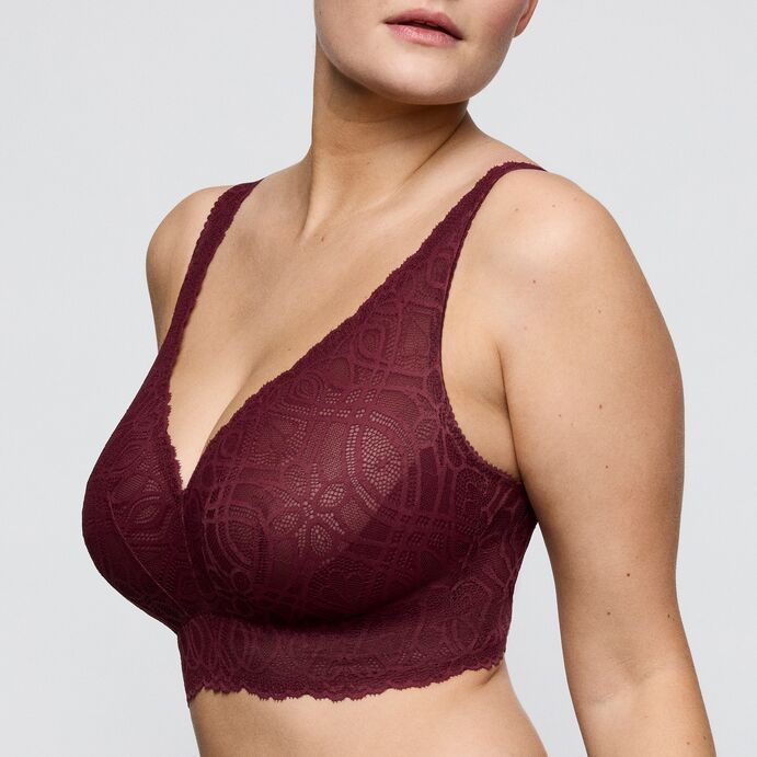 Maroon lace bra on a plain background