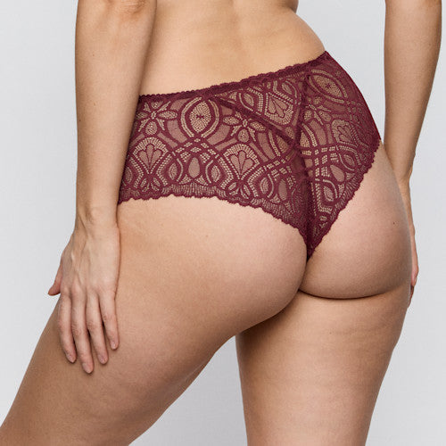 A close-up rear view of a model wearing burgundy lace high-waisted briefs against a light gray studio background.